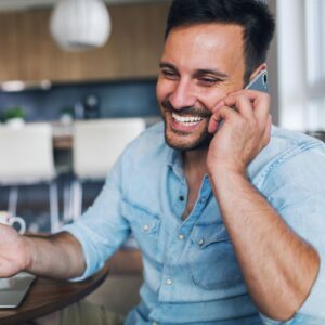 Man smiling while talking on the phone