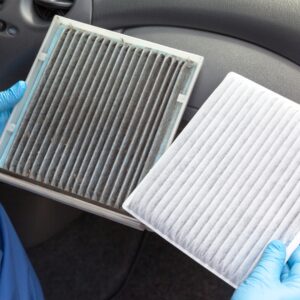 Gloved hands holding a clean and dirty air filter